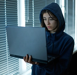 A tech expert girl with hoody searching on laptop in her hand